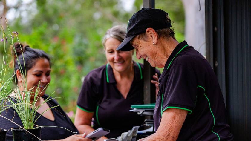 Friendly garden centre staff assisting a customer with plants at a local nursery in Australia